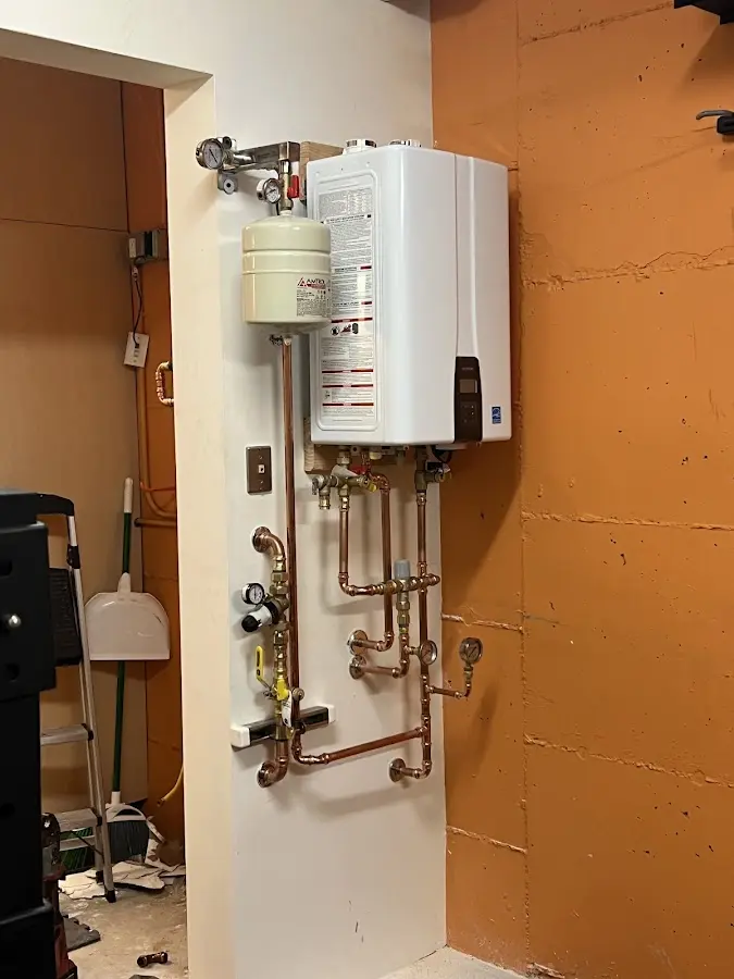 Plumbing technician inspecting water heater connections in Arden-Arcade